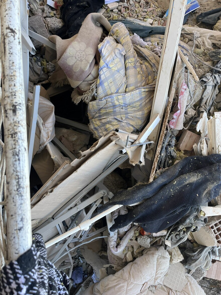 Ali and Merve Kafadenk's mangled bed frame sits atop the rubble of their destroyed apartment in Islahiye, Turkey. When the earthquake hit Feb. 6, the bedroom walls caved in, forming a concrete tent over their bed and protecting them.