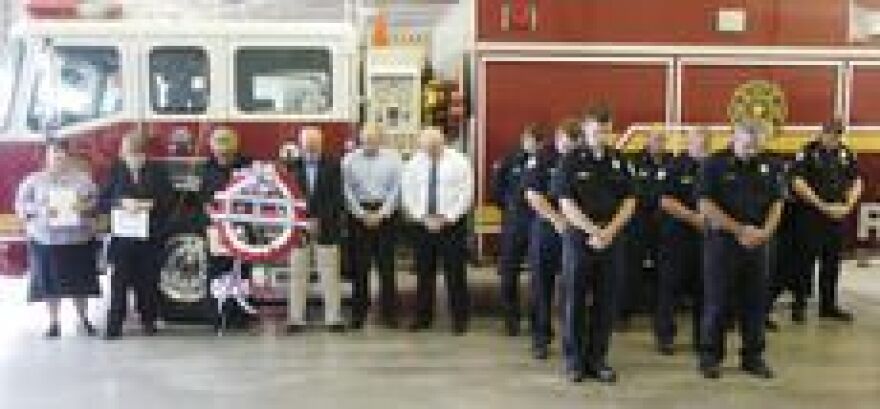 Elizabethtown firefighters and others bow their heads as a prayer is said Tuesday morning during a ceremony in remembrance of 9/11, at Elizabethtown Fire Department Headquarters.