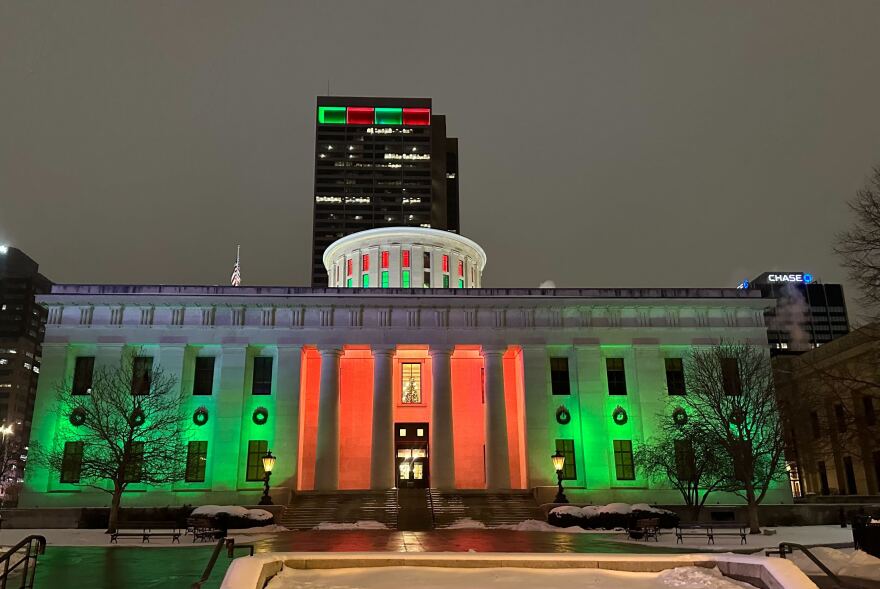The Ohio Statehouse lit with red and green for Christmas.