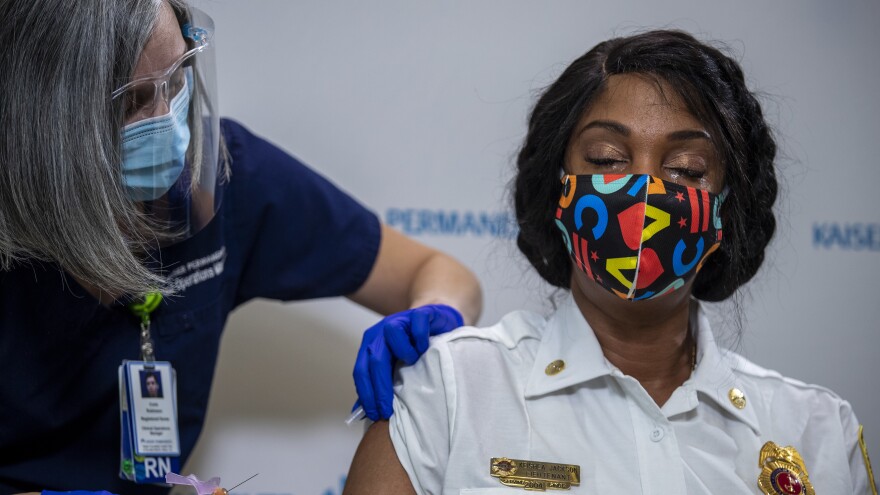 WASHINGTON, DC - DECEMBER 17: Kaiser Permanente registered nurse Corie Robinson administers the Pfizer-BioNTech COVID-19 vaccine to DC Fire and EMS Lieutenant Keishea Jackson during a vaccine event at Kaiser Permanente Capitol Hill December 17, 2020 in Washington, DC. (Photo by Shawn Thew-Pool/Getty Images)