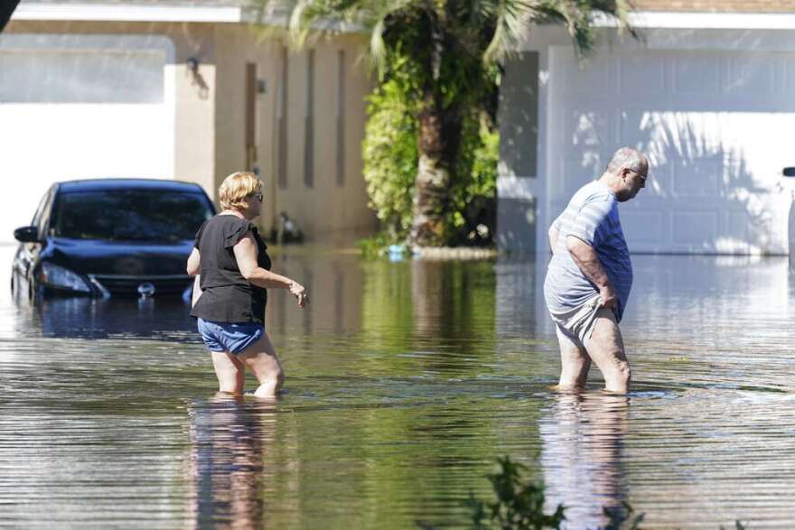 Residents check on their flooded home, in the wake of Hurricane Ian, Friday, in Orlando. (AP Photo/John Raoux)