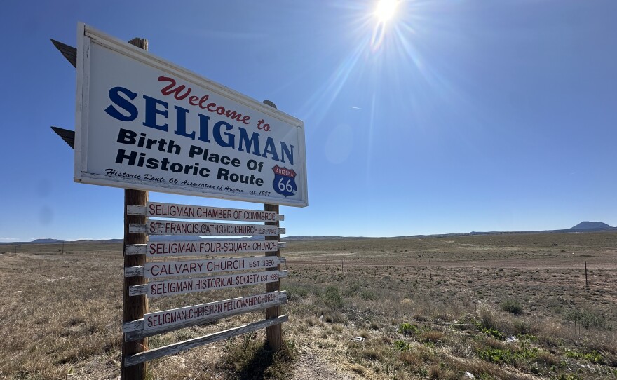white welcome to seligman sign in a field