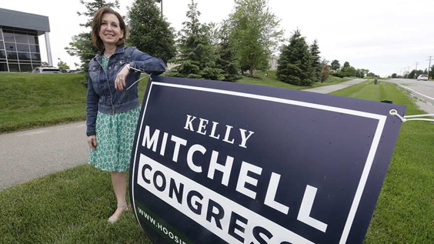 Indiana State Treasurer Kelly Mitchell stands by a campaign sign, Thursday, May 28, 2020, in Westfield, Ind. Mitchell is a candidate for Indiana's 5th Congressional District. More Republican women than ever are seeking House seats this year after the 2018 election further diminished their limited ranks in Congress. But so far it appears that any gains this November could be modest.