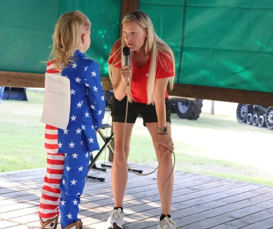 Paul Maier speaks with emcee Leslie Shirek on-stage at the Clay County Fairgrounds in Barnesville on July 9 | MPR News