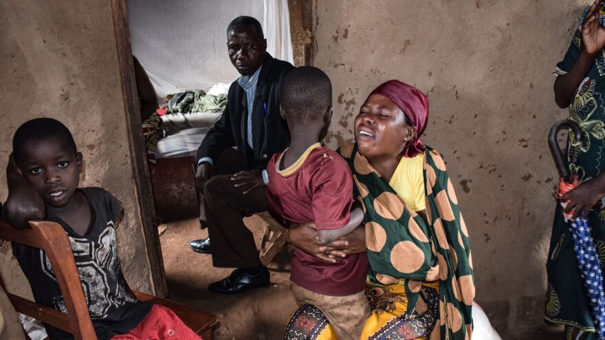 Family members of victims killed by an armed group mourn in the village of Ruhagarika on Saturday, where 26 people were killed, in northwestern Burundi.