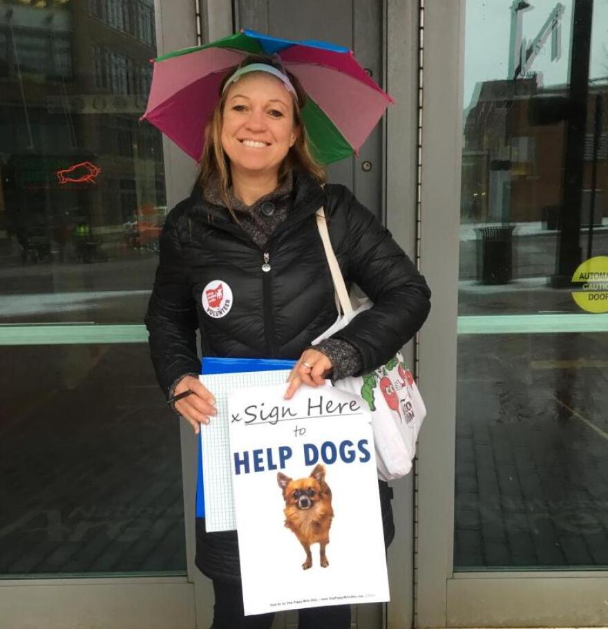 A volunteer collects signatures for the Stop Puppy Mills amendment outside Nationwide Arena in Columbus in February. 