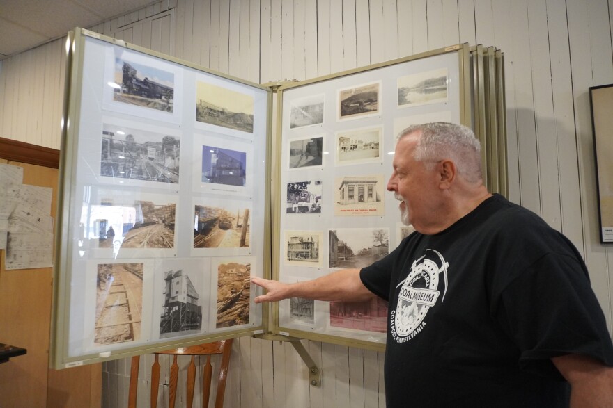 Richard Snyder II, the museum's curator, flips through old pictures of Coalport and its mines. 
