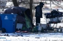 A homeless person checks a cart in front of a tent during a cold day in Chicago, Thursday, Jan. 22, 2026.