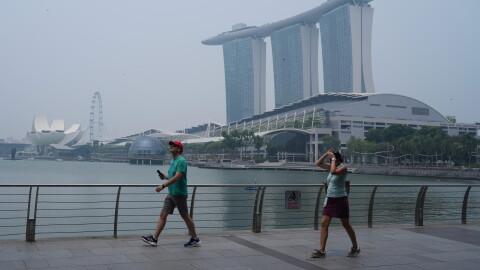 People exercise along the Marina Bay waterfront promenade as the Marina Bay Sands resort is shrouded in transboundary haze from fires in Indonesia, pushing the city’s air quality back into the unhealthy range, Monday, Sept. 14, 2026 in Singapore.
