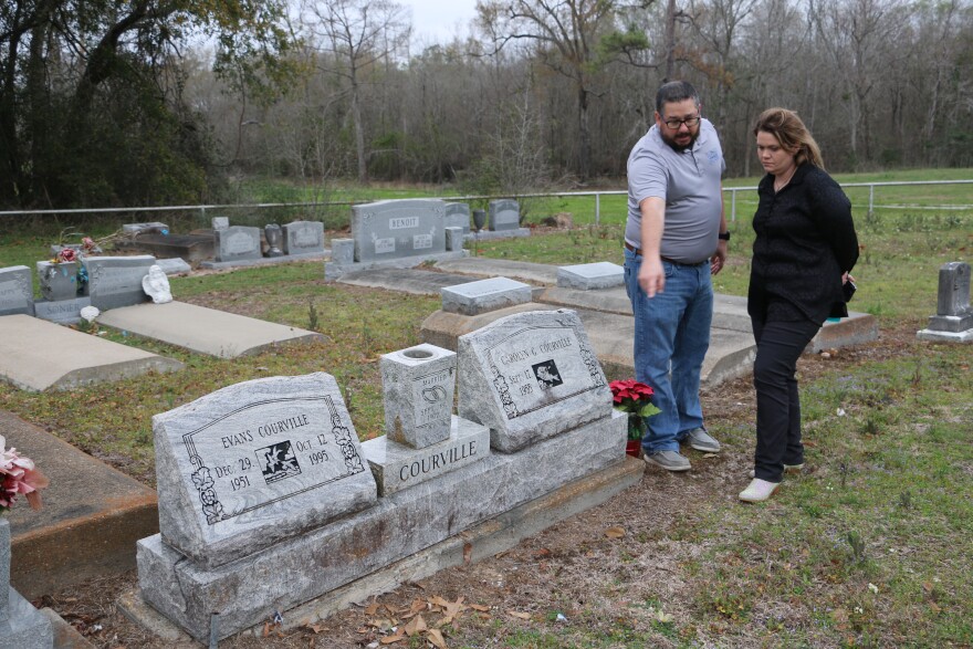 Emily Dalfrey and Charlie Hunter examine the headstones of Dalfrey’s aunt and uncle, Evans and Carolyn Courville, in Niblett’s Bluff Cemetery on February 27, 2024. Hunter’s company helped recover and rebury the caskets of Dalfrey’s family members after they were washed away during flooding in 2016.