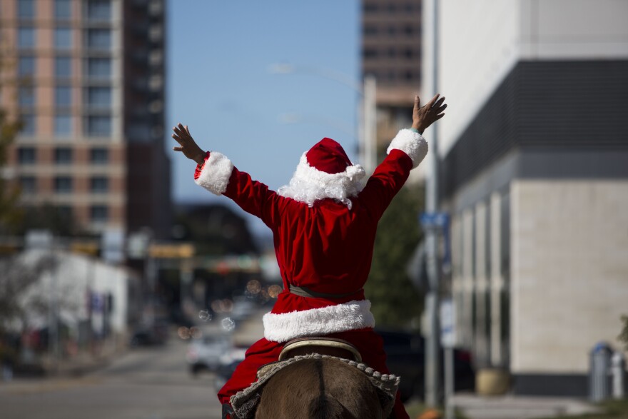 Grey Horse rides his mule dressed as Santa Claus.