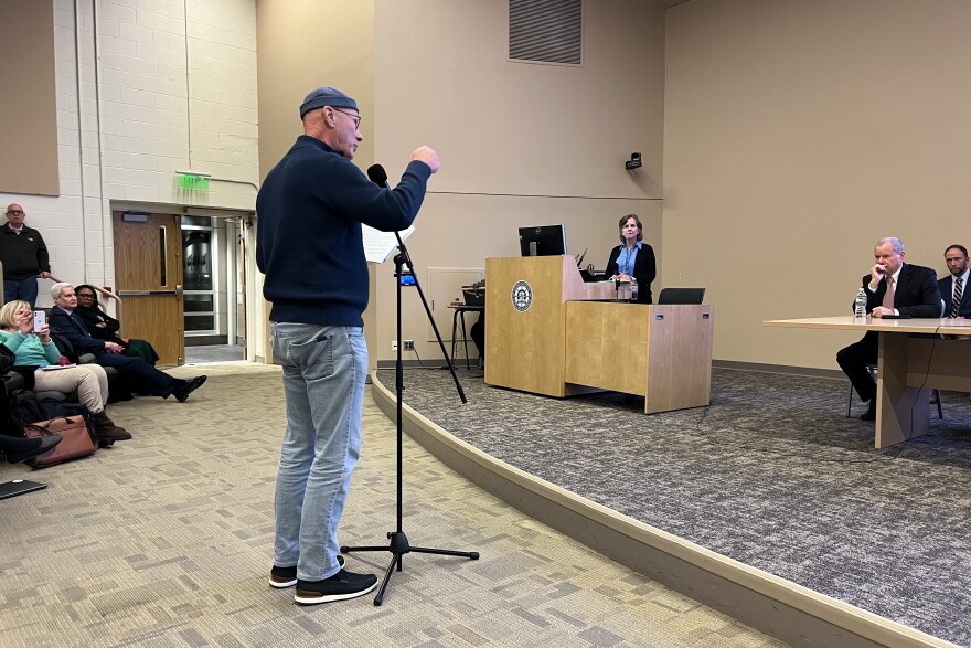 Jay Batson of Bourne speaks at meeting on the Cape Cod bridges replacement project held at Massachusetts Maritime Academy, Dec. 16, 2025. Listening at the podium is Luisa Paiewonsky, executive director of the Megaprojects Delivery Office at the Massachusetts Department of Transportation.