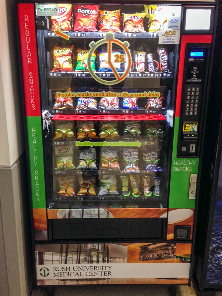 A vending machine with the DISC, or "Delays to Influence Snack Choice," installed. On the display window, a written decal tells customers they'll have to wait for an extra 25 seconds for unhealthy snacks.<strong></strong>