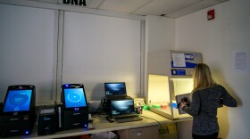 Cheryl Carreiro, Deputy Director of Forensic Biology & DNA Technical Operations at the CT Forensic Science Laboratory, demonstrates how samples are handled before being analyzed in the lab’s rapid DNA testers (left).