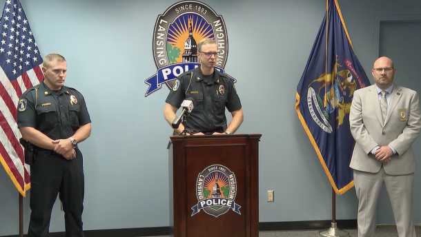 Lansing Police Chief Rob Backus in the middle talking. 