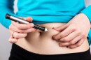 Diabetes patient taking shot by syringe with dose of insulin in the abdomen 