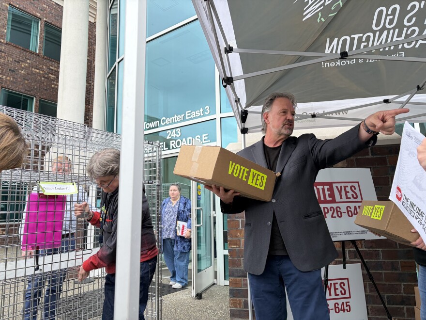 Brian Heywood holds a box and points.