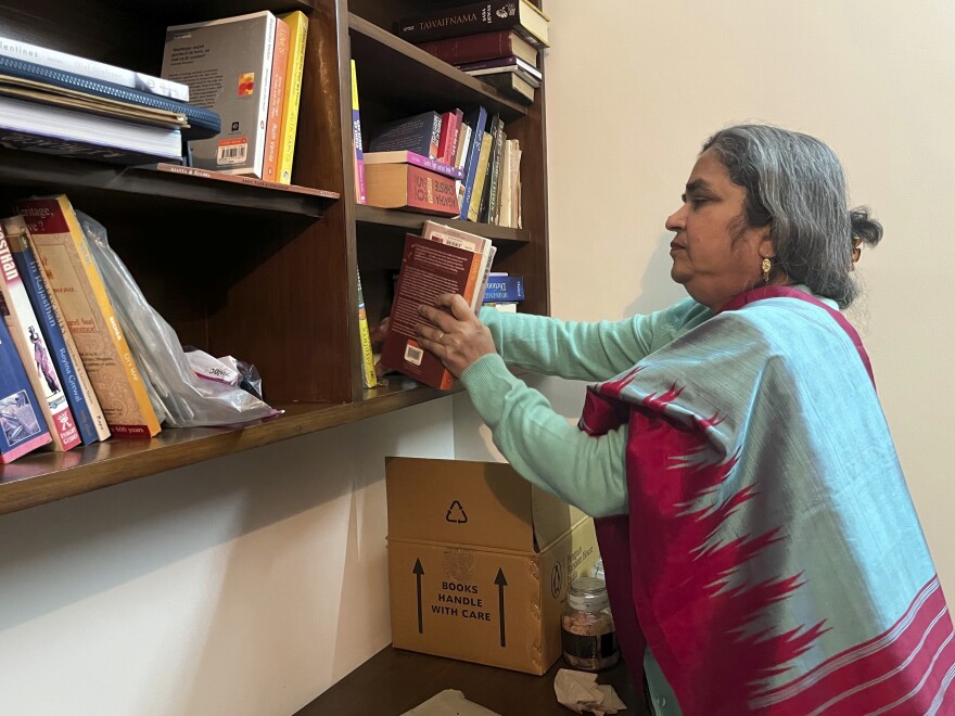 Ruth Vanita, an expert on gender studies and author of "Love's Rite: Same-Sex Marriage in India and the West" adjusts books at her home in Gurgaon, India, Jan. 27, 2023.