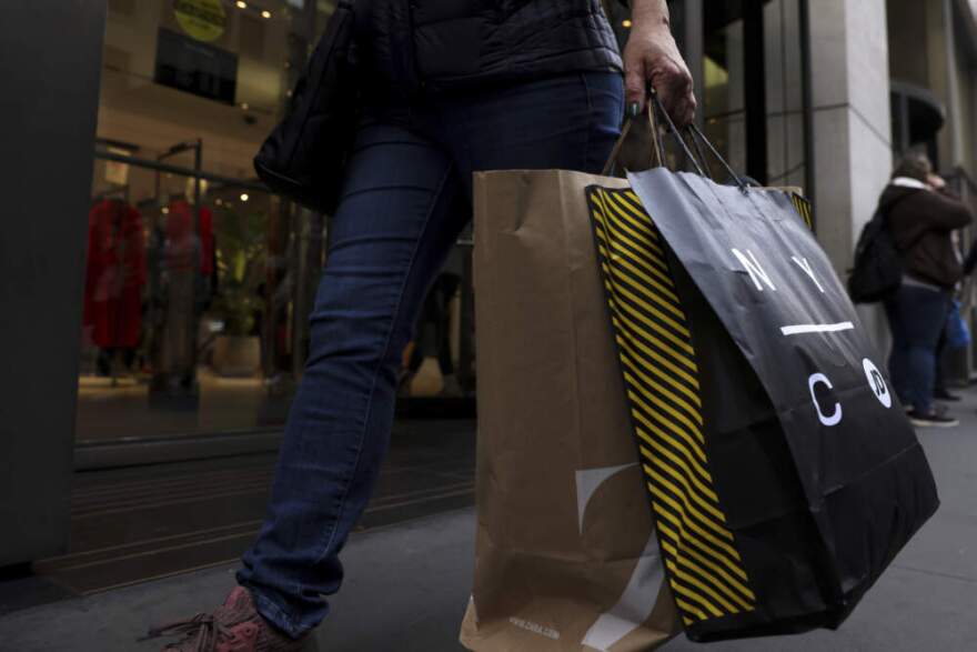 A shopper carries bags down Fifth Avenue in New York. (Julia Nikhinson/AP)