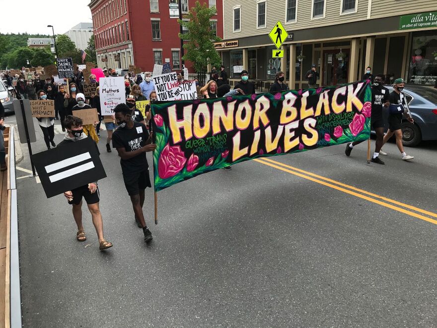 People carrying a banner reading honor Black lives