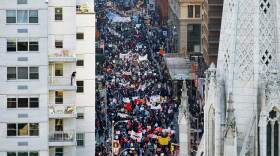 Protestors marching down a street in New York, as seen from above.
