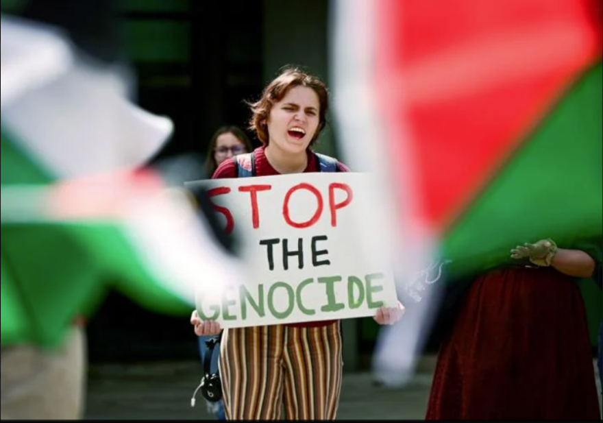 Mary Wren, a third-year University of Idaho student, is framed by Palestinian flags while shouting in agreement with a speaker at the Palestine Week of Action demonstration on campus in Moscow Thursday. (Liesbeth Powers/Moscow-Pullman Daily News)