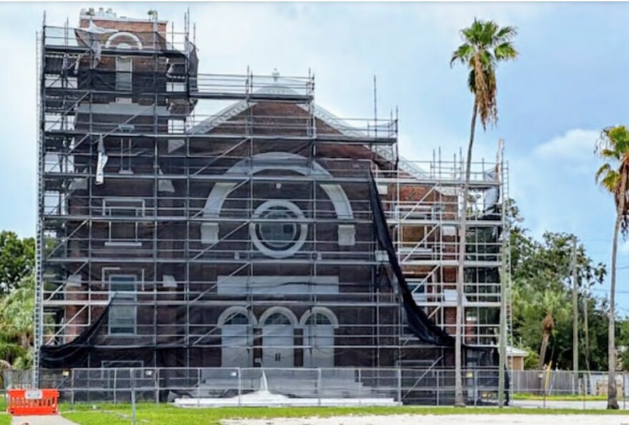 An old brick church surrounded by scaffolding