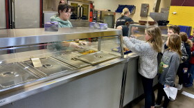 A staff member serves school lunches to students in the Maple Valley-Anthon Oto Community School District.