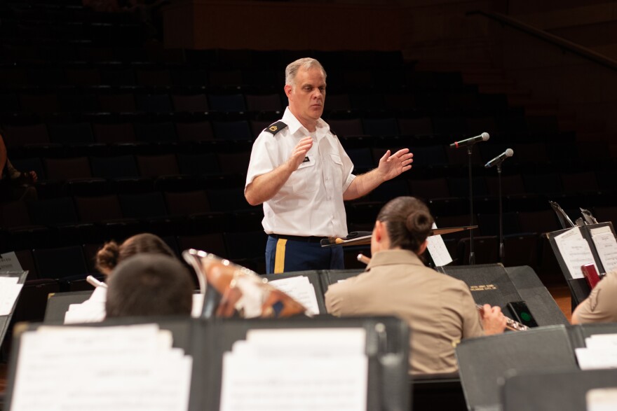 Sergeant First Class Chad Bratton leads the 145th Army Band in a warm-up routine before the June 24 concert at Quartz Mountain State Park.