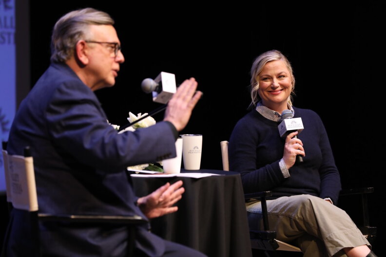 George Prentice and Amy Poehler sit in chairs during an interview on stage at the Sun Valley Film Festival.