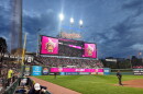 A wide shot of sold-out Progressive Field under the lights with Banana Ball logos on the scoreboard.