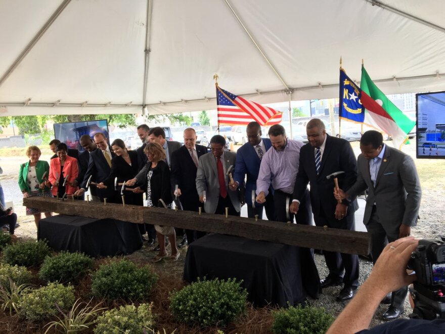 Officials pounded spikes into railroad ties Friday morning to formally mark the start of construction on Gateway Station.