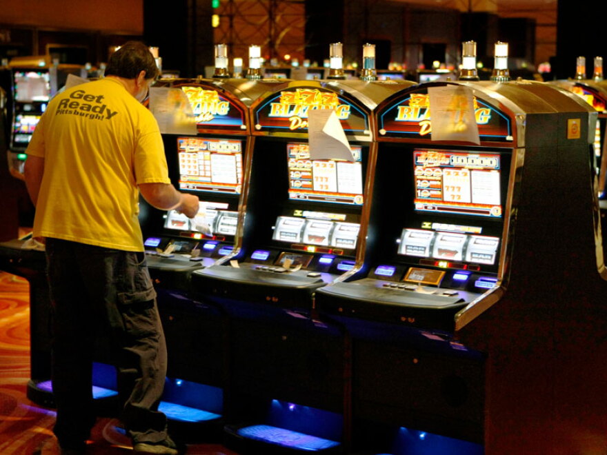 A technician looks over a slot machine at the new Rivers Casino in Pittsburgh in late July. The casino opened in early August, part of an increasing expansion of casino gambling in states.