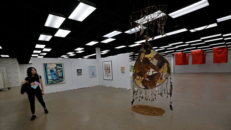 Chelsea Garcia of Dallas walks through a exhibit during Vignette Art Fair at Dallas Market Hall, Saturday, Nov. 4, 2023, in Dallas. Texas Vignette selected 47 women artists from 216 applicants, who are working across the state of Texas in all mediums and disciplines of art.