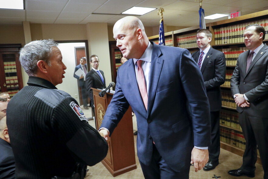 Acting Attorney General Matthew Whitaker shakes hands with Newtown Police Chief Tom Synan during a news conference, Friday, Nov. 30, 2018, in Cincinnati.