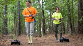 ODU students Darian Dean, M.P.H. and Willow Baker use robots to drag a cloth through the underbrush, attracting ticks for study.