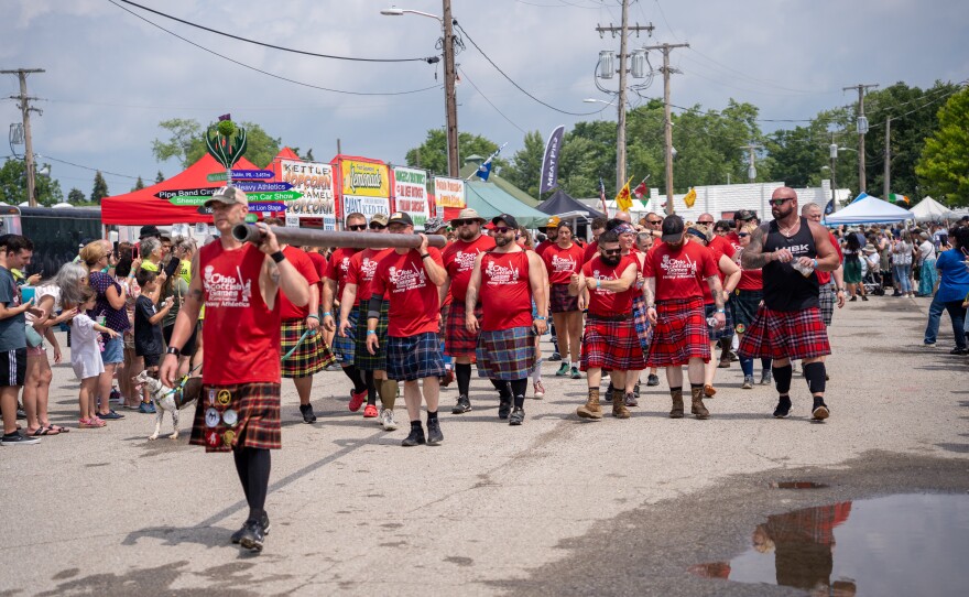 Group of men in red shirts march together.
