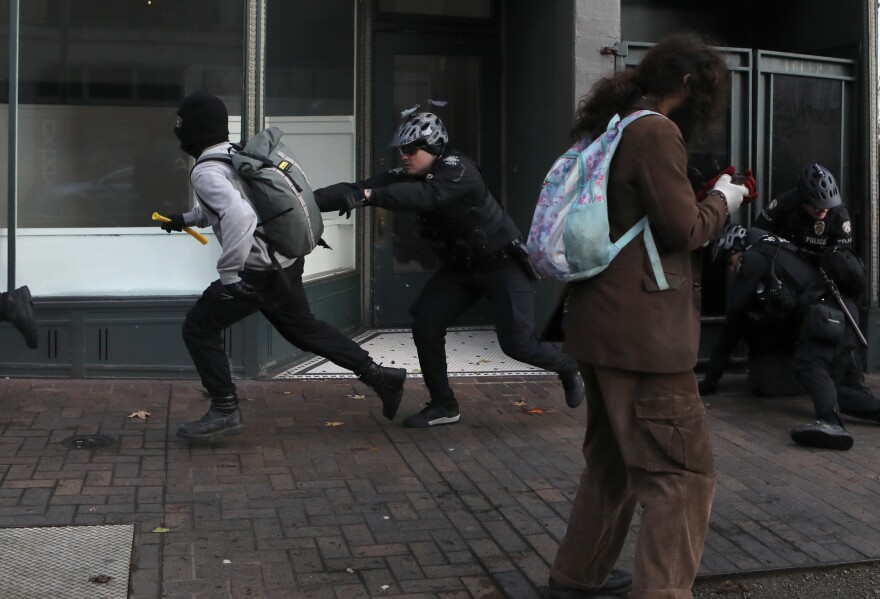 A Seattle police officer chases an anti-fascist protester during the United Against Hate rally by the Washington Three Percent in Seattle last month.