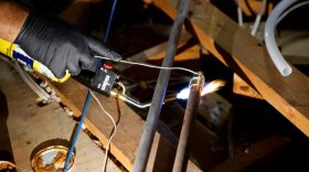 Plumber Randy Calazans with One Call Plumbing repairs a burst pipe in a home in Houston, Texas.