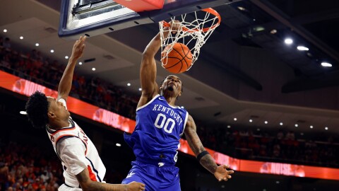 Kentucky guard Otega Oweh (00) slam dunks the ball over Auburn guard Tahaad Pettiford (0) during the first half of an NCAA college basketball game Saturday, Feb. 21, 2026, in Auburn, Ala. (AP Photo/Butch Dill)