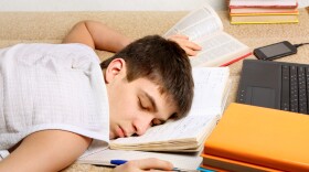 Tired Teenager sleeping on the Books at the Home