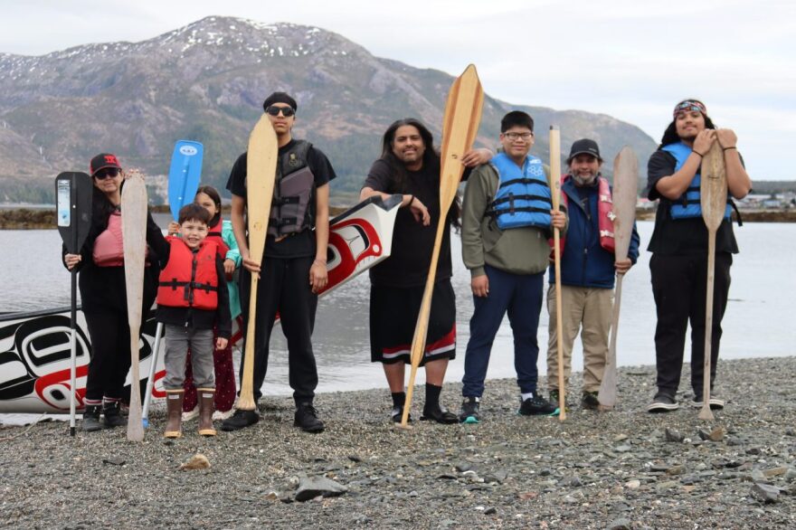 Paddlers pose with the Spirit of Our Ancestors on One Tree Island during the canoe’s annual awakening on Saturday.