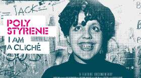 The documentary poster for "Poly Styrene: I Am a Cliché" pictures a smiling Poly Styrene in front of a graffitied wall.
