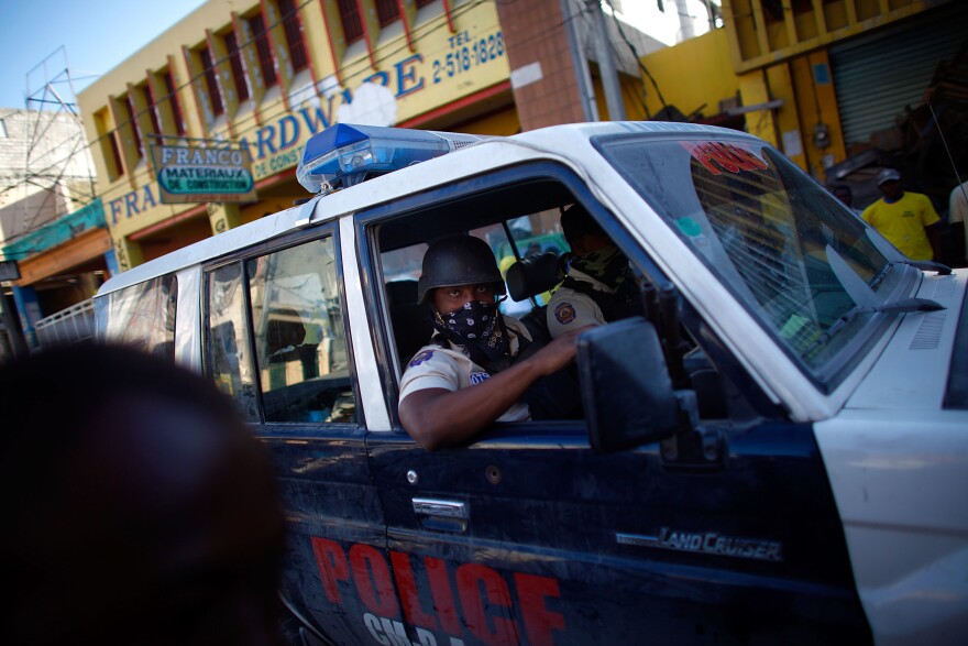 Police patrol the streets in the commercial district of Port-au-Prince. Nine days after the quake hit, residents have turned to digging out as the looting is significantly tamped down by the police.