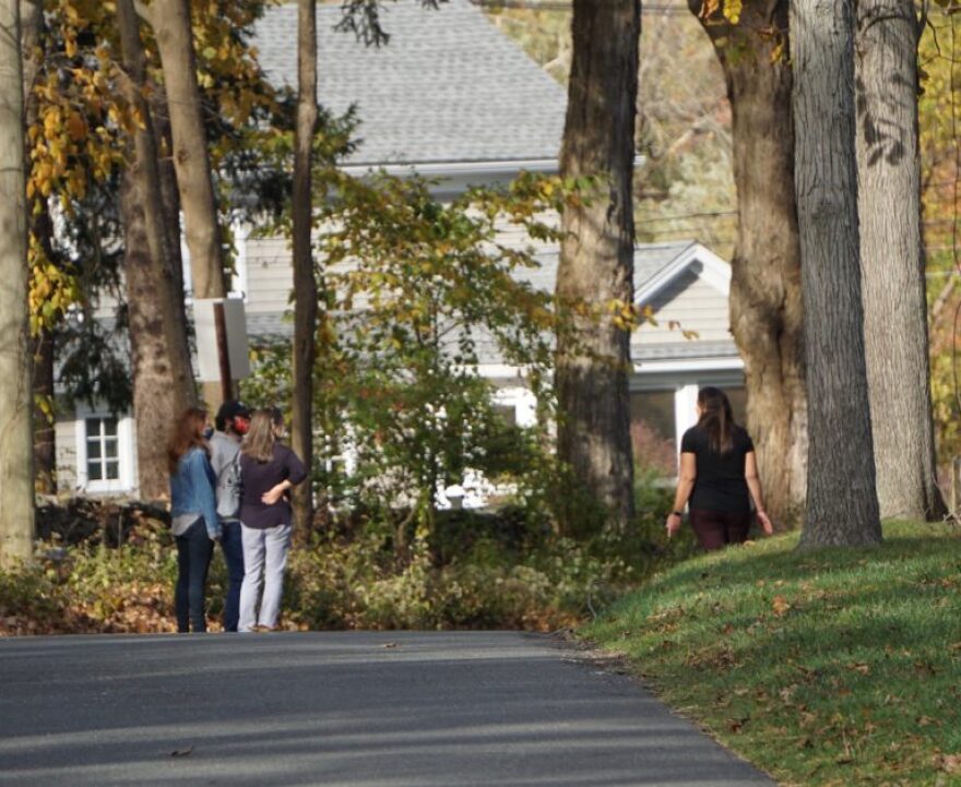 Door knocking means hiking in Ridgefield. Aimee Berger-Girvalo, left, and two volunteers talk to an undecided voter. On Sunday, she covered six miles.