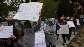 Jesus Zepeda Salas marches in Ellensburg Sunday, Sept. 29, holding a sign challenging Kittitas County Sheriff Gene Dana’s legacy as the longest-serving sheriff in Washington State. Immigration rights advocates called on Dana to cancel a contract with Immigration and Customs Enforcement before his retirement in October. CREDIT: Enrique Pérez de la Rosa/NWPB