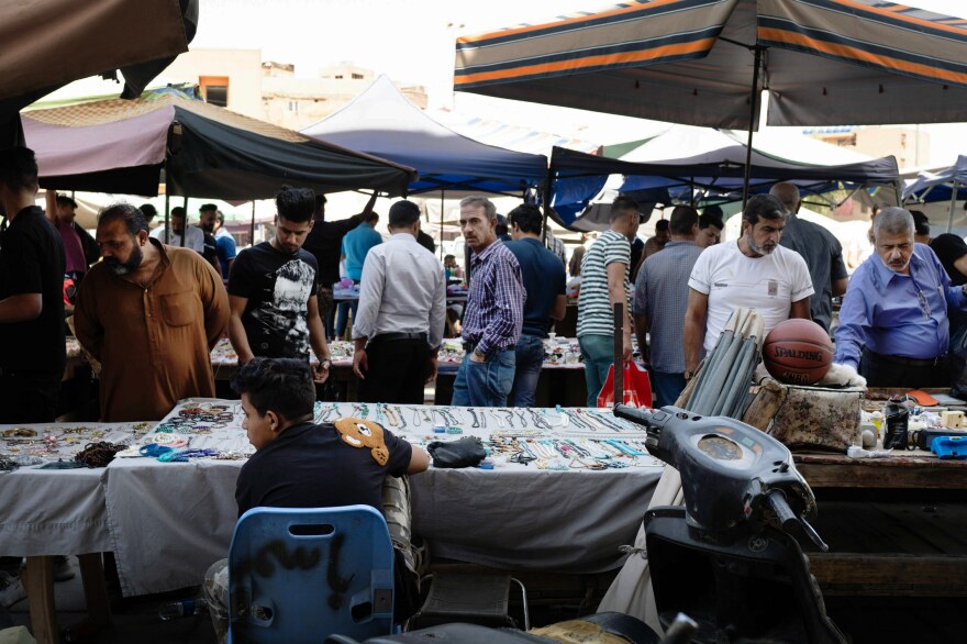 Vendors sell various goods to shoppers at "the Thieves' Market" in Baghdad.