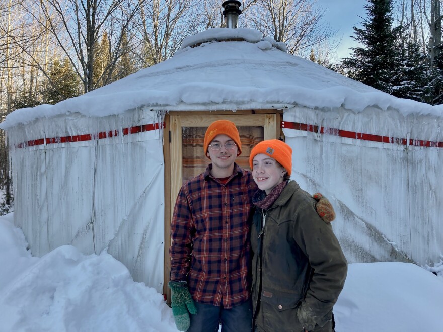 A picture of two people with arms around each other and orange hats.