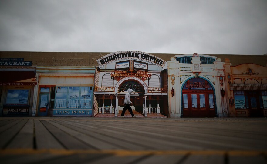 A man walks down a seemingly empty boardwalk as Hurricane Sandy approaches on Sunday in Atlantic City, N.J.