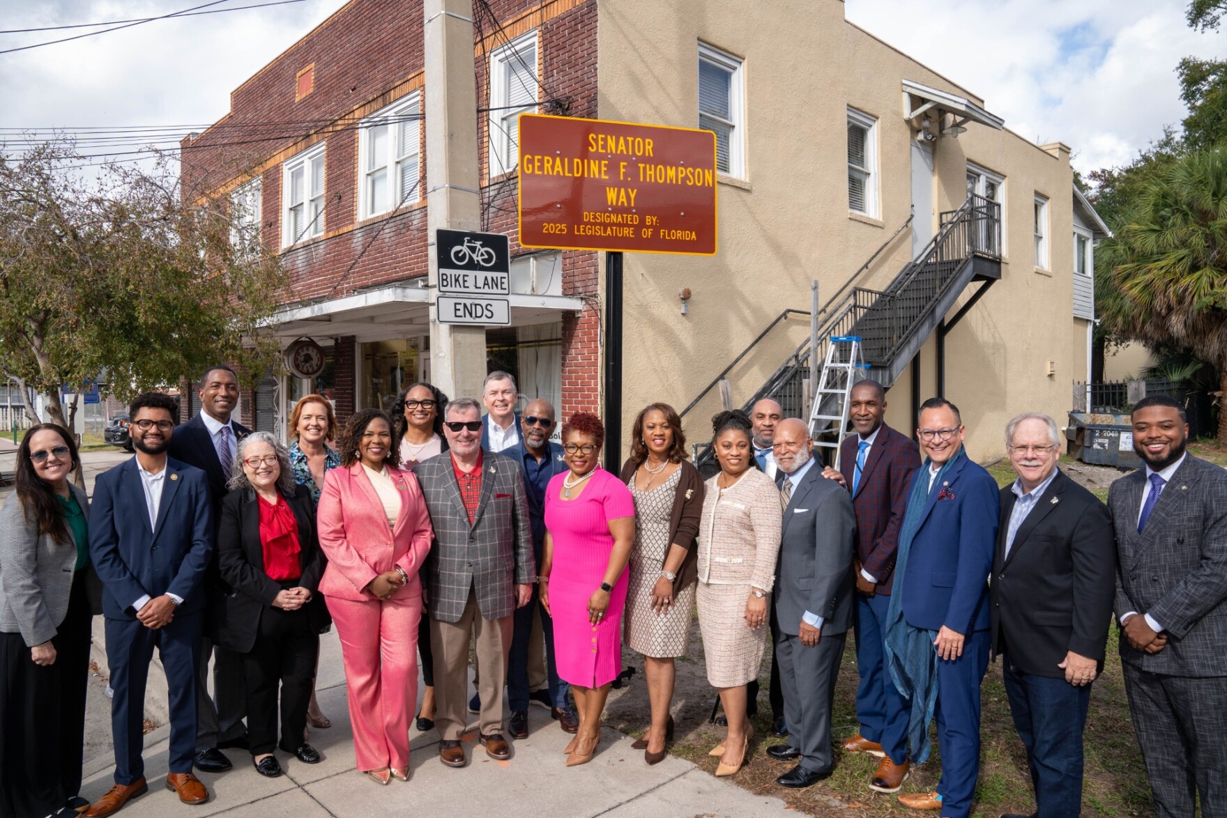 Elected leaders from across Central Florida stand in front of Thompson's new street sign.